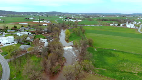 Aerial-view-of-rapids-on-a-small-river-in-the-American-countryside,-farms-and-country-houses-on-the-banks,-Conestoga-River-in-Lancaster-County,-Pennsylvania