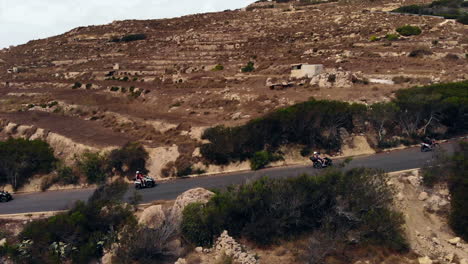 Grupo-Montando-Quads-Disfrutando-De-Conducir-Por-La-Carretera-De-Montaña-En-Gozo,-Malta
