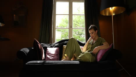 Sophisticated-Woman-Relaxing-in-Sofa-Swiping-on-Tablet