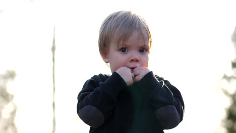 Slow-motion-shot-of-toddler-boy-pointing-away-on-a-sunny-spring-day,-static-medium-shot
