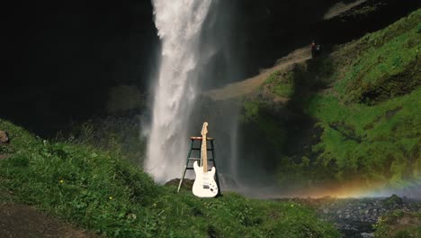Man-playing-guitar-in-front-of-a-beautiful-waterfall-in-Iceland-7