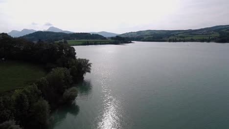 Vuelo-Junto-A-La-Costa-Sobre-La-Naturaleza,-Lago-Gruyère,-Suiza