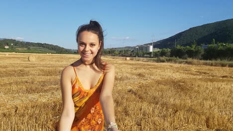 Young-brunette-girl-kissing-towards-camera-in-a-wheat-field-at-the-beginning-of-summer-while-singing