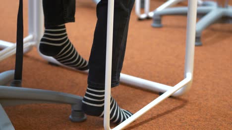 Childs-feet-in-black-white-striped-socks-swinging-feet-under-desk