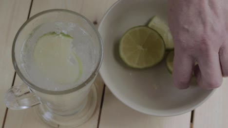 Dropping-lime-slices-into-glass-of-fizzy-water
