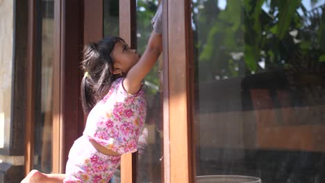 Hübsches-Kleines-Mädchen,-Das-Beim-Fensterputzen-Im-Haus-Hilft