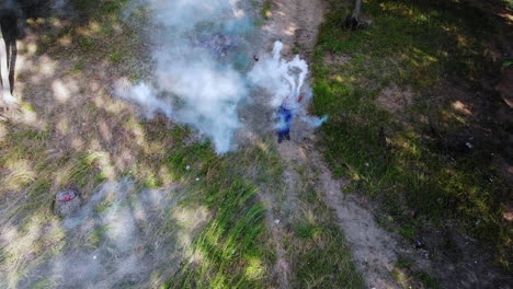 Man-With-Smoke-Bomb-Walking-In-Forest
