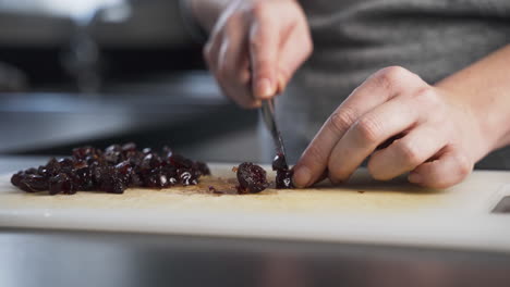 Close-up-view-of-glazed-cherries-being-chopped-and-sliced-to-make-mince-pie-filling