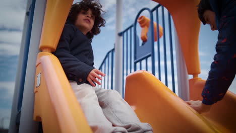 Young-boy-climbing-up-a-slide-in-a-playground