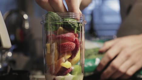 Hinzufügen-Von-Frischem-Obst-Und-Gemüse-In-Den-Mixbehälter-Für-Einen-Smoothie---Nahaufnahme
