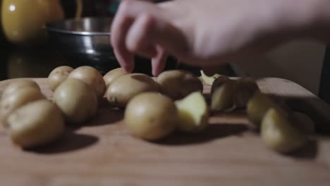 Female-Slowly-Cutting-The-Potato-In-A-Haft-On-A-Cutting-Board---Close-Up-Shot