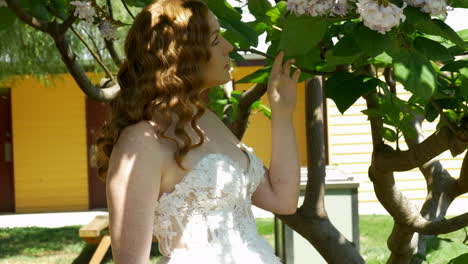 Rothaarige-Braut,-Die-Blumen-In-Einem-Baum-Betrachtet