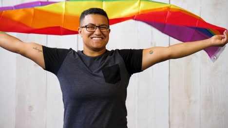 Persona-Queer-Negra-Sosteniendo-La-Bandera-Del-Orgullo-Gay-Ondeando-Sobre-Su-Cabeza