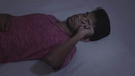 Concept-of-a-sleeping-disorder-or-insomnia,-Young-Indian-male-adult-trying-to-sleeping-during-the-night-at-home