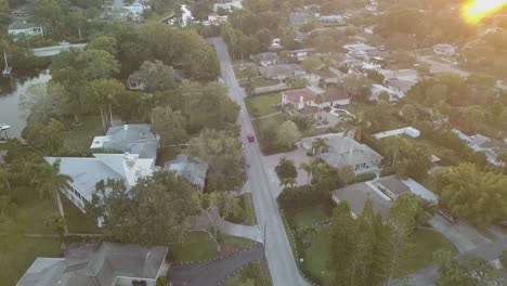 Luftaufnahme-Des-Roten-Sportwagens,-Der-Bei-Sonnenuntergang-Durch-Die-South-Florida-Street-Fährt