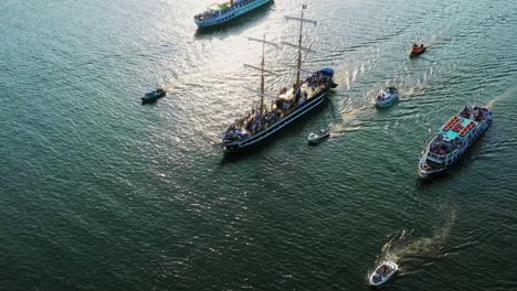 Aerial-view-of-a-sailing-boat-escorted-with-other-boats