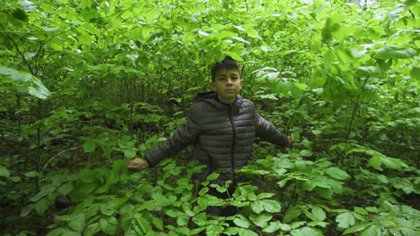 Young-boy-emerging-from-thick-forest-understorey