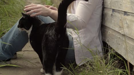 Frau-Im-Garten-Freundet-Sich-Mit-Freundlicher-Schwarz-weißer-Katze-An