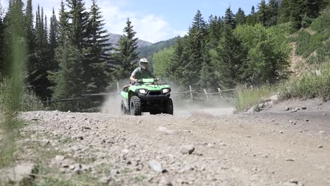 Shot-of-an-ATV-Rider-driving-his-quad-really-fast-around-a-corner,-leaving-a-large-dirt-cloud-behind-him-1