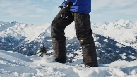 Persona-Con-Traje-De-Snowboard-Caminando-Por-La-Nieve-Acumulada-En-El-Paisaje-Alpino