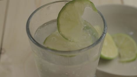Dropping-lime-slices-into-a-refreshing-glass-of-fizzy-water