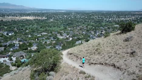 Drone-Shot-following-an-active-man-running-on-the-outdoor-mountain-trails-above-Draper-City,-Utah-1
