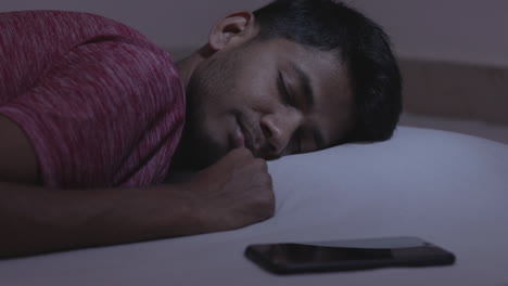 Concept-showing-of-irregular-sleep-or-sleep-deprivation-caused-due-to-mobile-phone,-young-adult-got-the-message-while-sleeping-causing-disturbance-and-affects-the-sleep-and-health-1