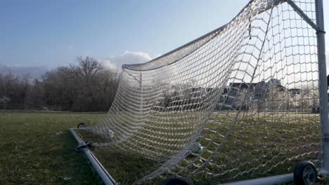 SLOW-MOTION:-A-soccer-ball-slams-an-icy-net-of-a-soccer-goal-exploding-shattered-ice-into-the-air