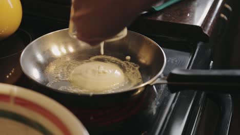 Pouring-The-Pancake-Batter-Using-A-Glass-Pitcher-Into-The-Hot-Skillet---Close-Up-Shot