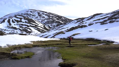 Woman-trekking-in-the-mountains-and-crossing-a-river