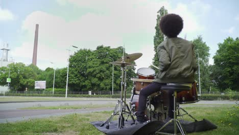 Young-Enthusiastic-Musician-Isolated-Playing-Drums-Outside