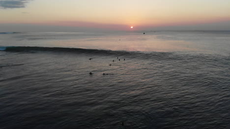 Unglaubliche-Luftaufnahme-Eines-Surfers,-Der-Eine-5-6-Fuß-Welle-In-Bali-Reitet,-Offener-Ozean,-Gruppe-Von-Surfern-Und-Sonnenuntergang-Im-Hintergrund