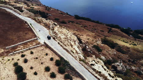 Aerial-Quad-Bike-Driving-Along-Stunning-Coastal-Road,-Gozo-Malta
