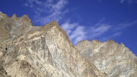 Bald-mountain-tops,-peaks-against-the-clear-blue-sky,-pan-right-shot