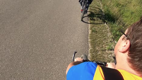A-cyclist-wearing-an-orange-vest-rides-his-bike-2