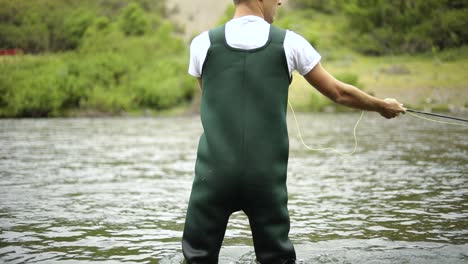 Slow-Motion-Shot-of-a-Caucasian-male-fisherman-casting-his-hook-while-Fly-Fishing