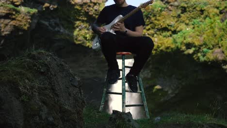 Man-playing-guitar-in-front-of-a-beautiful-waterfall-in-Iceland-9