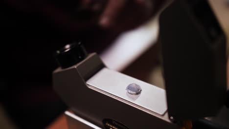 Putting-diamond-stone-into-a-specialized-microscope-with-tweezers