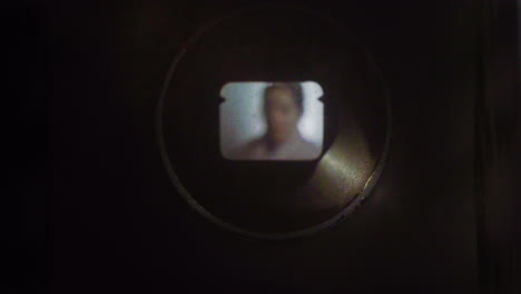 Woman-on-camera-through-old-dirty-8mm-viewfinder-with-film-strip-effect-and-flares