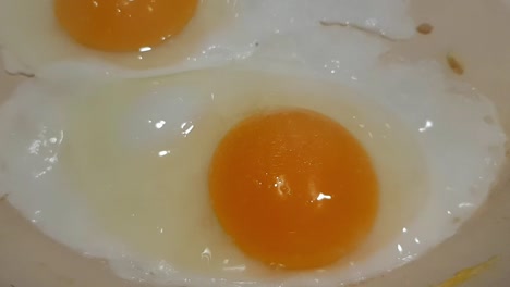 Close-up-view-of-eggs-being-cooked-in-a-pan