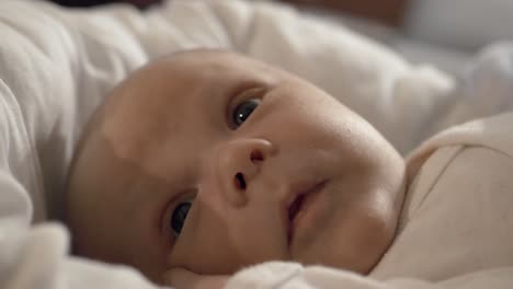 Adorable-beautiful-newborn-baby-boy-lying-in-cot