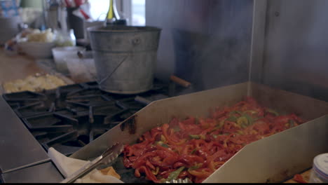 Sliced-red-peppers-grill-on-a-stove-in-a-country-kitchen-steam-rises