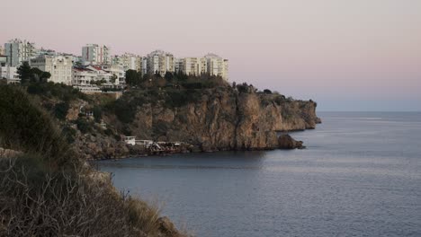 Full-shot,-scenic-view-of-the-sea-and-cliffs-of-Antalya,-buildings-in-the-back-in-turkey