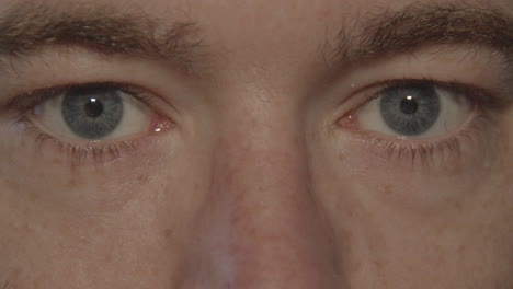 Close-up-of-pair-of-blue-eyes-opening-and-looking-into-camera