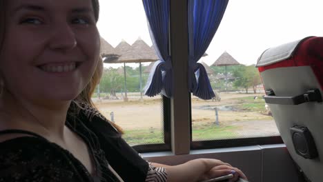 Ein-Mädchen-Beobachtet-Vögel-Und-Nashörner-Durch-Ein-Busfenster