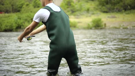Slow-Motion-Shot-of-a-Caucasian-male-fisherman-casting-his-hook-while-Fly-Fishing-4