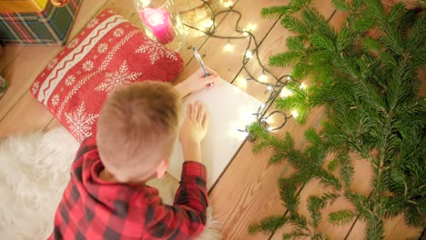 El-Niño-Está-Tirado-En-El-Suelo-Y-Escribiendo-Su-Lista-De-Deseos-Para-Navidad