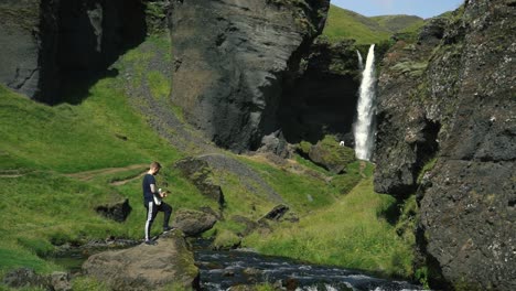Man-playing-guitar-in-front-of-a-beautiful-waterfall-in-Iceland-12