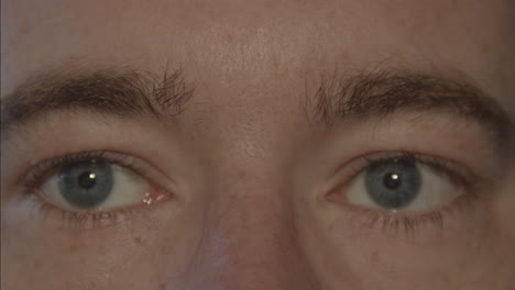 Close-up-of-pair-of-blue-male-eyes-looking-around-and-blinking-slowly