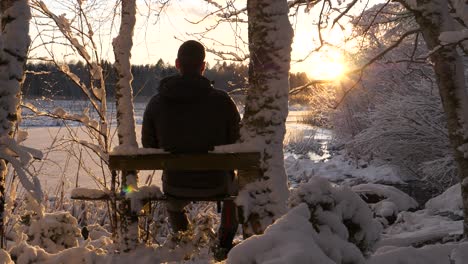 Man-enjoying-winter-wonderland-view,-frosty-trees-at-golden-sunset